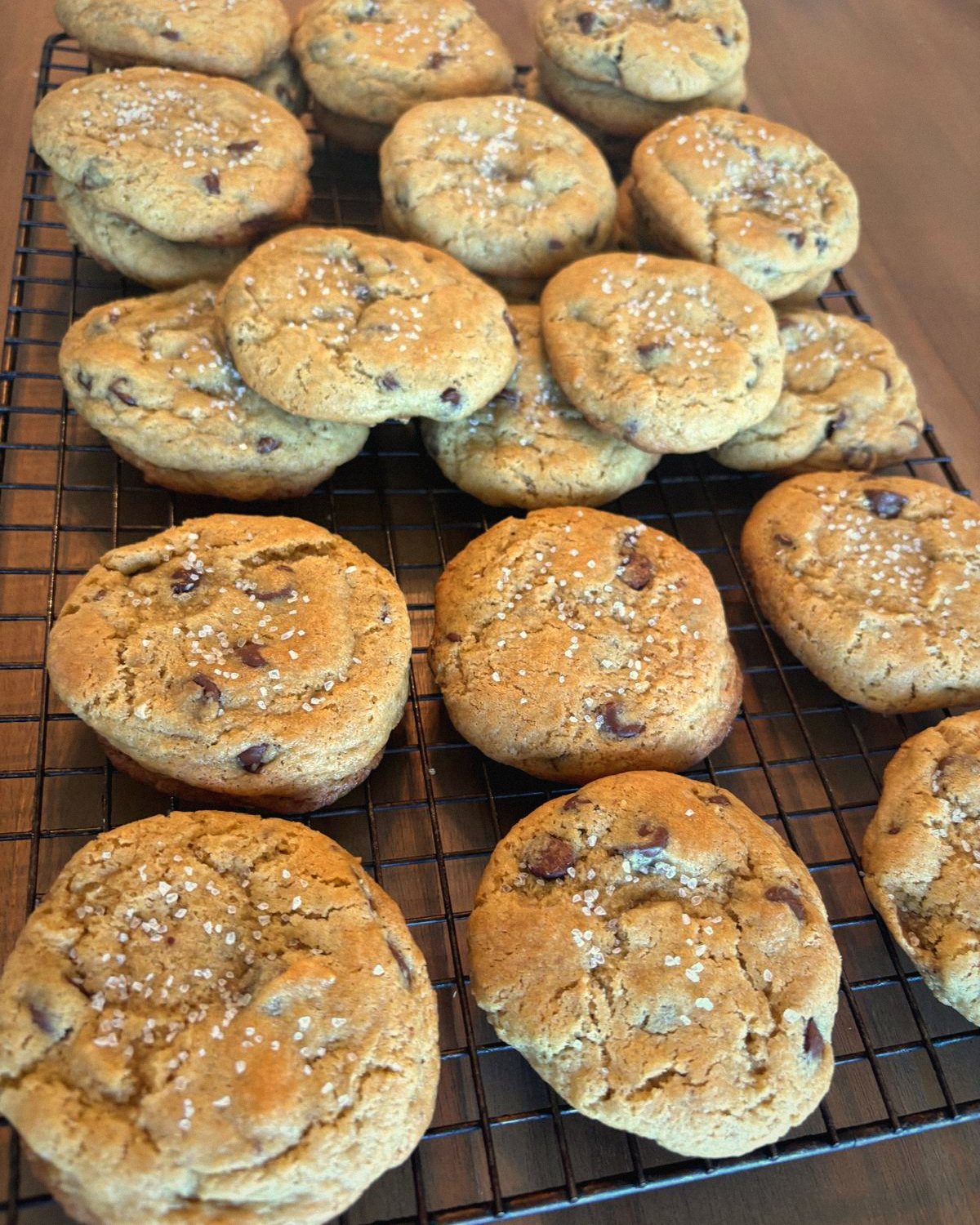 Sourdough chocolate chip cookies with flaky salt on a cooling rack