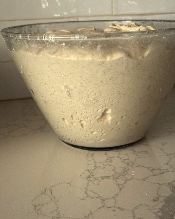 Dough rising in a glass bowl
